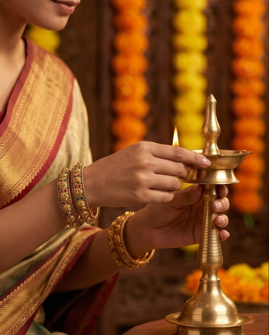 Person in traditional attire holding a brass lamp with a blurred decorative background