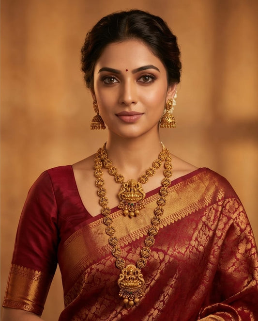 Woman wearing traditional jewelry and a saree with a warm background