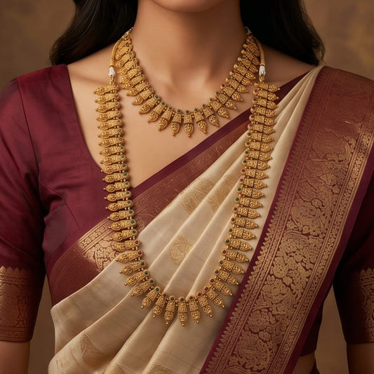 Woman wearing a traditional saree with gold jewelry against a warm background